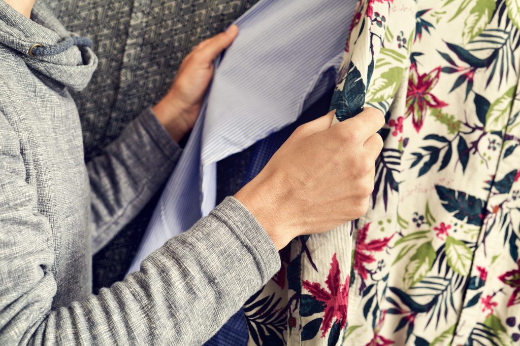 Man sorting shirts to declutter