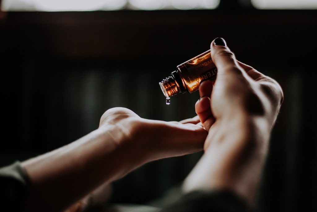 person pouring essential oil